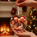 May include: A clear, round Christmas ornament with a family photo inside, held by a hand. The family is wearing Santa hats. The ornament has a white ribbon for hanging and the text "Your Text Here".