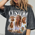 May include: Dark gray t-shirt with the word "CUSTOM" in a silver, metallic font. The shirt features a collage of photos of a person, with a variety of poses and expressions. The shirt has a vintage, distressed