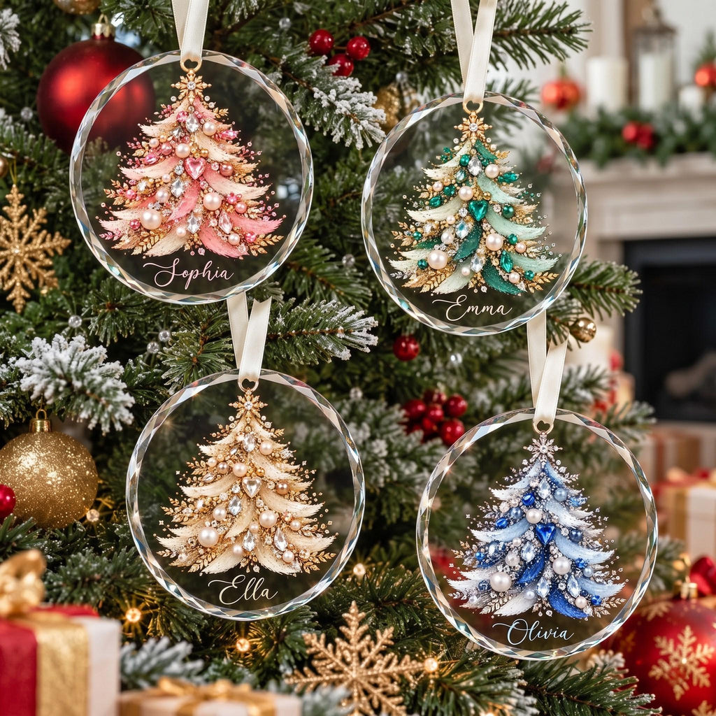 May include: Four circular clear glass ornaments featuring detailed illustrations of Christmas trees decorated with pearls and crystals. Each ornament displays a unique color scheme of pink, green, gold, or blue, with th